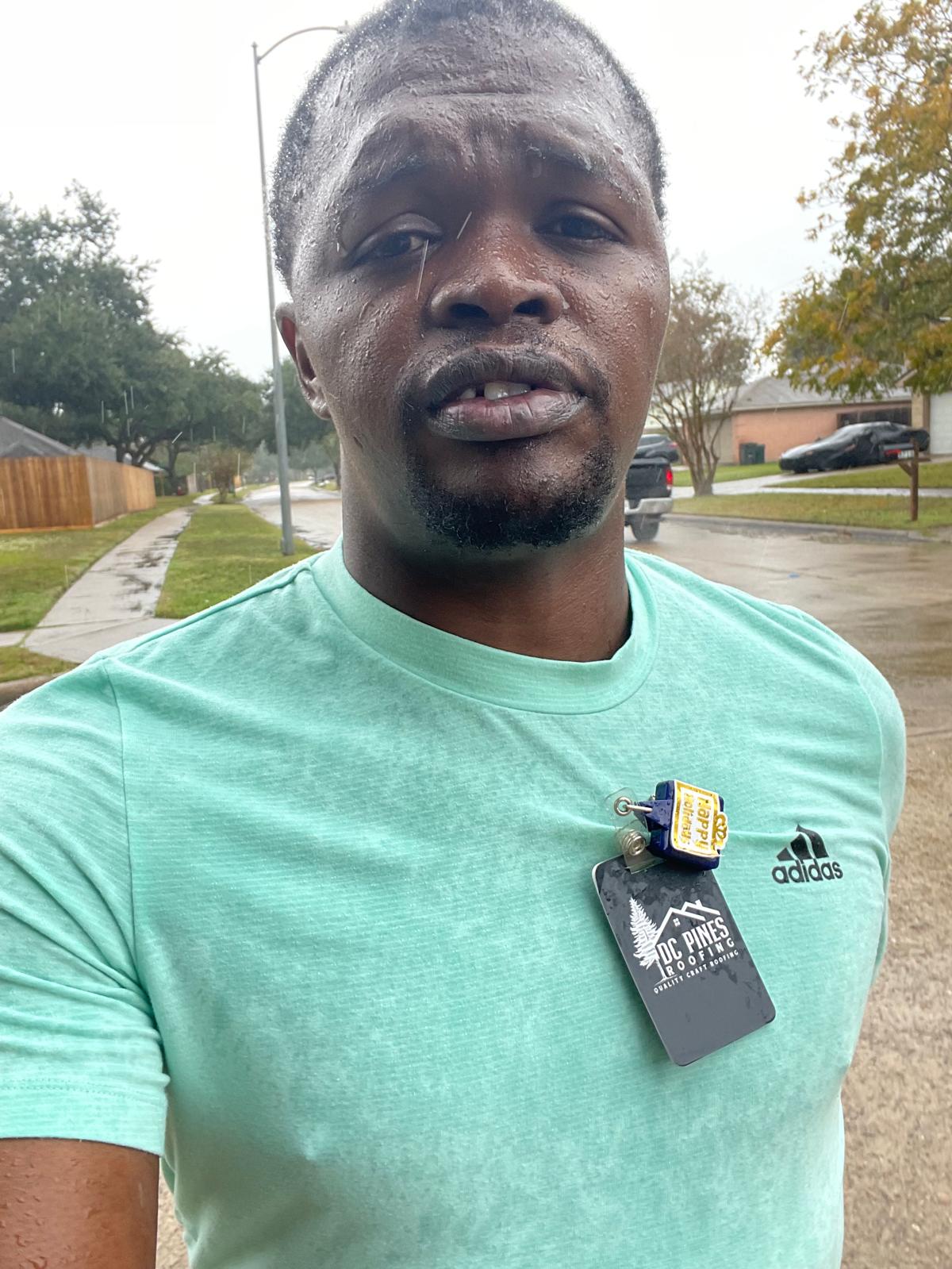 DC Pines Roofing bilingual team member with company ID badge working a Houston neighborhood