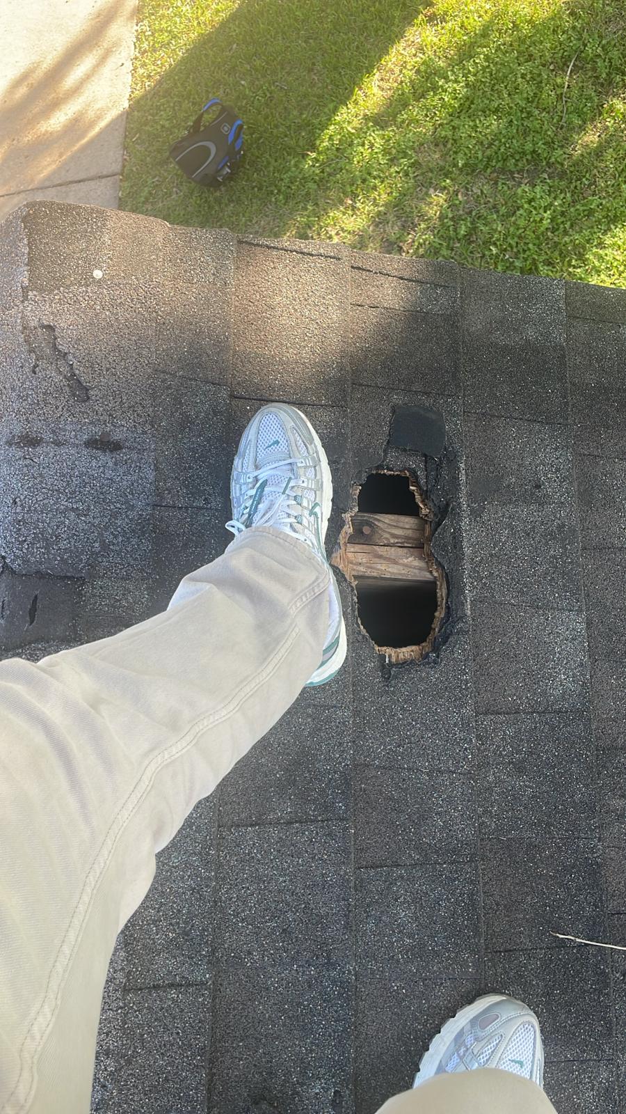DC Pines Roofing technician inspecting a section of aged shingles and decking on a Houston rooftop