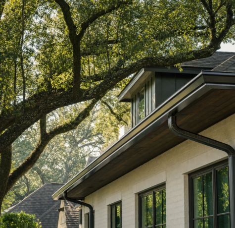 Houston home with mature live oak canopy overhanging seamless aluminum gutters installed by a Houston gutter guards company
