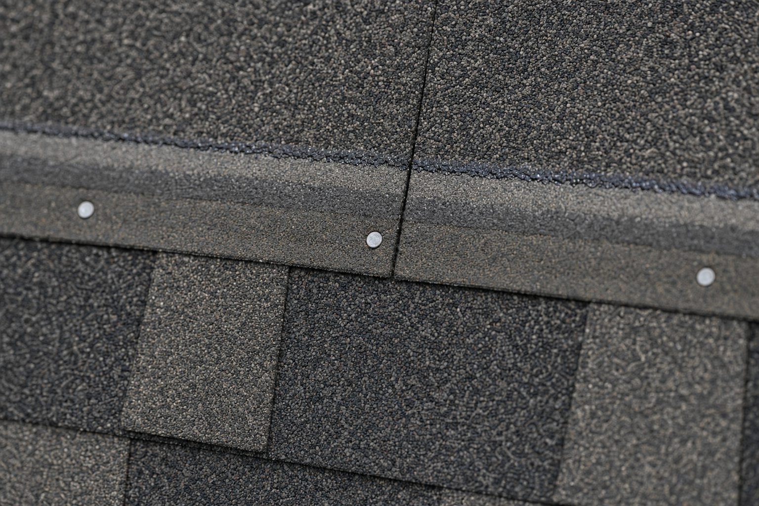 Macro close-up of asphalt shingle courses showing houston shingle nailing zone and visible nail heads