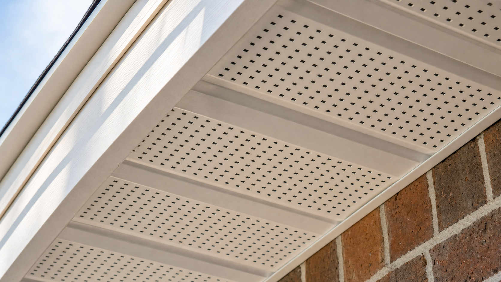 Perforated aluminum soffit vent panel on the underside of a Houston home eave