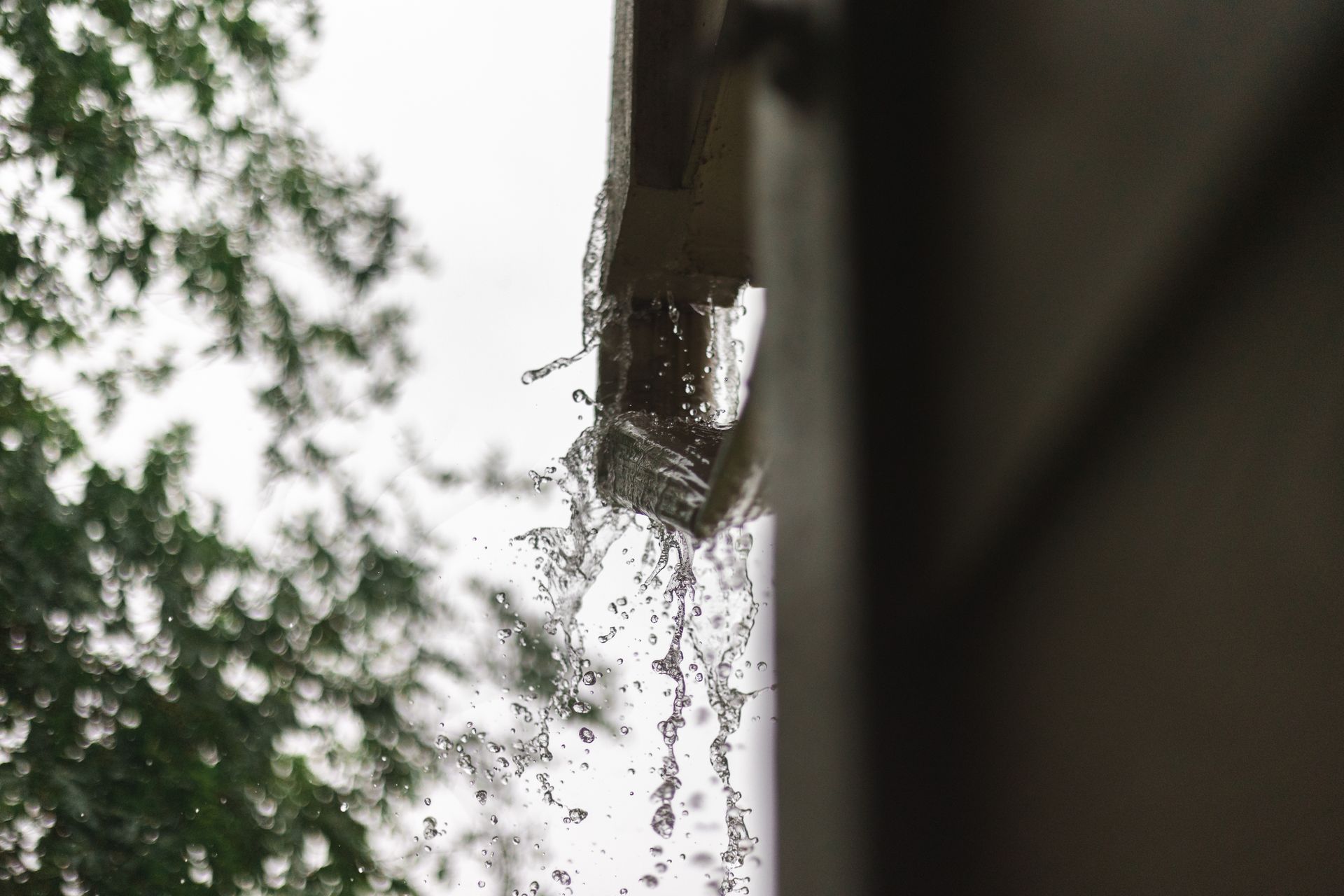 Water pouring off a Houston roof with no gutter system