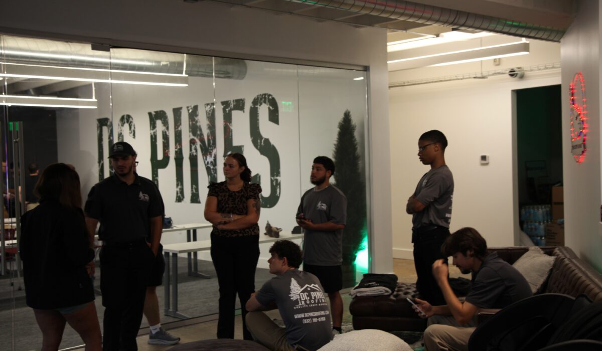 The DC Pines Roofing team gathered together during a Houston office meeting, capturing the collaborative culture that starts every crew day