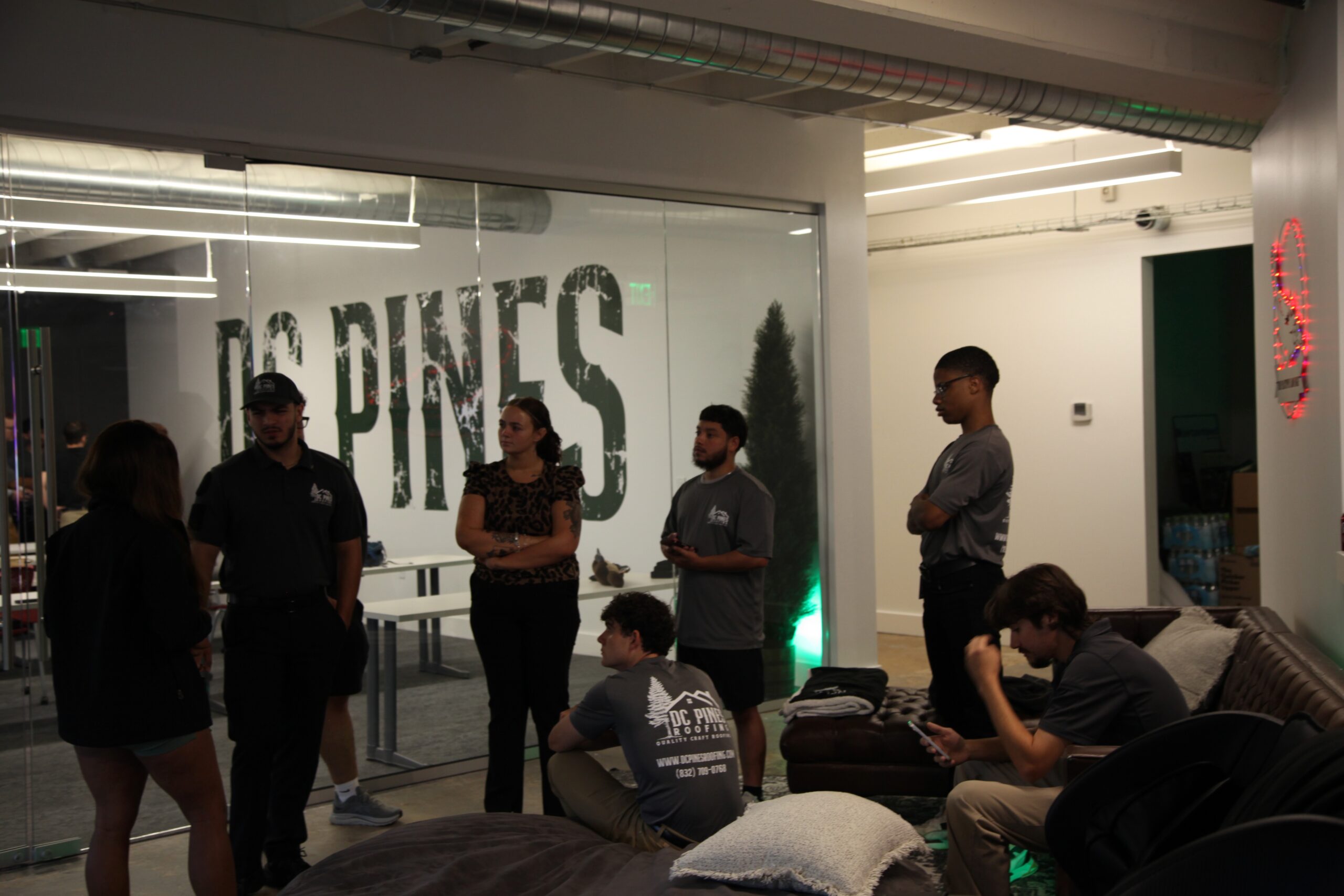 The DC Pines Roofing team gathered together during a Houston office meeting, capturing the collaborative culture that starts every crew day