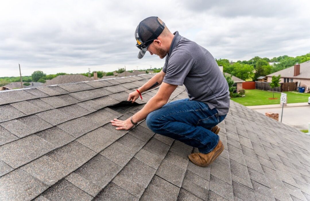 DC Pines Roofing technician on a Houston-area roof inspecting shingles during a routine service visit