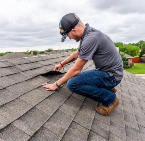DC Pines Roofing technician on a Houston-area roof inspecting shingles during a routine service visit