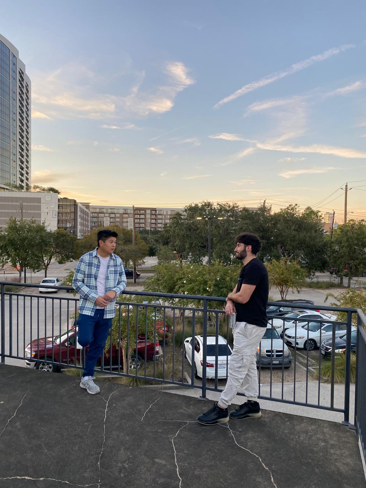 Two DC Pines Roofing team members with the Houston skyline in the background