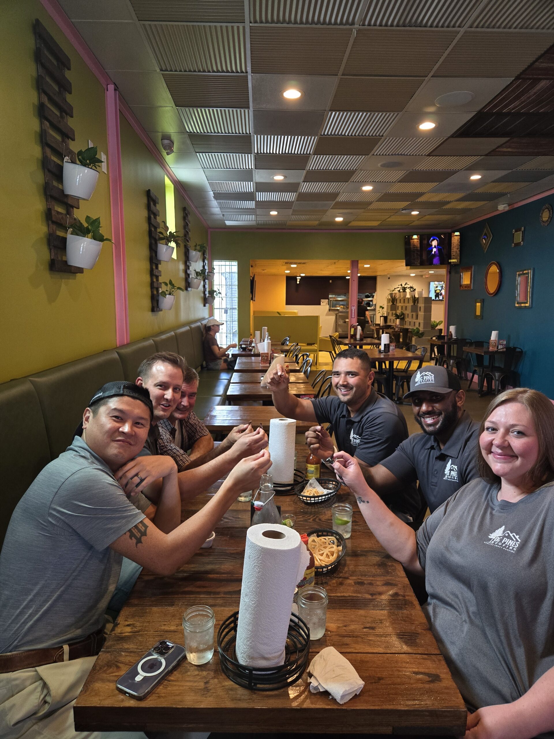 DC Pines Roofing crew gathered around a restaurant table in Houston