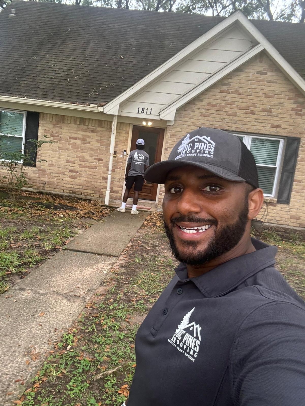 DC Pines Roofing crew member on a Houston jobsite reviewing next steps