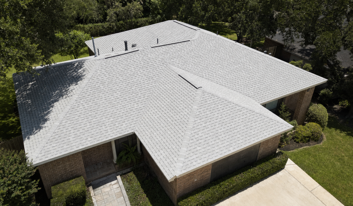 Aerial view of a Houston hip roof covered in light-colored cool-roof asphalt shingles designed for high solar reflectance