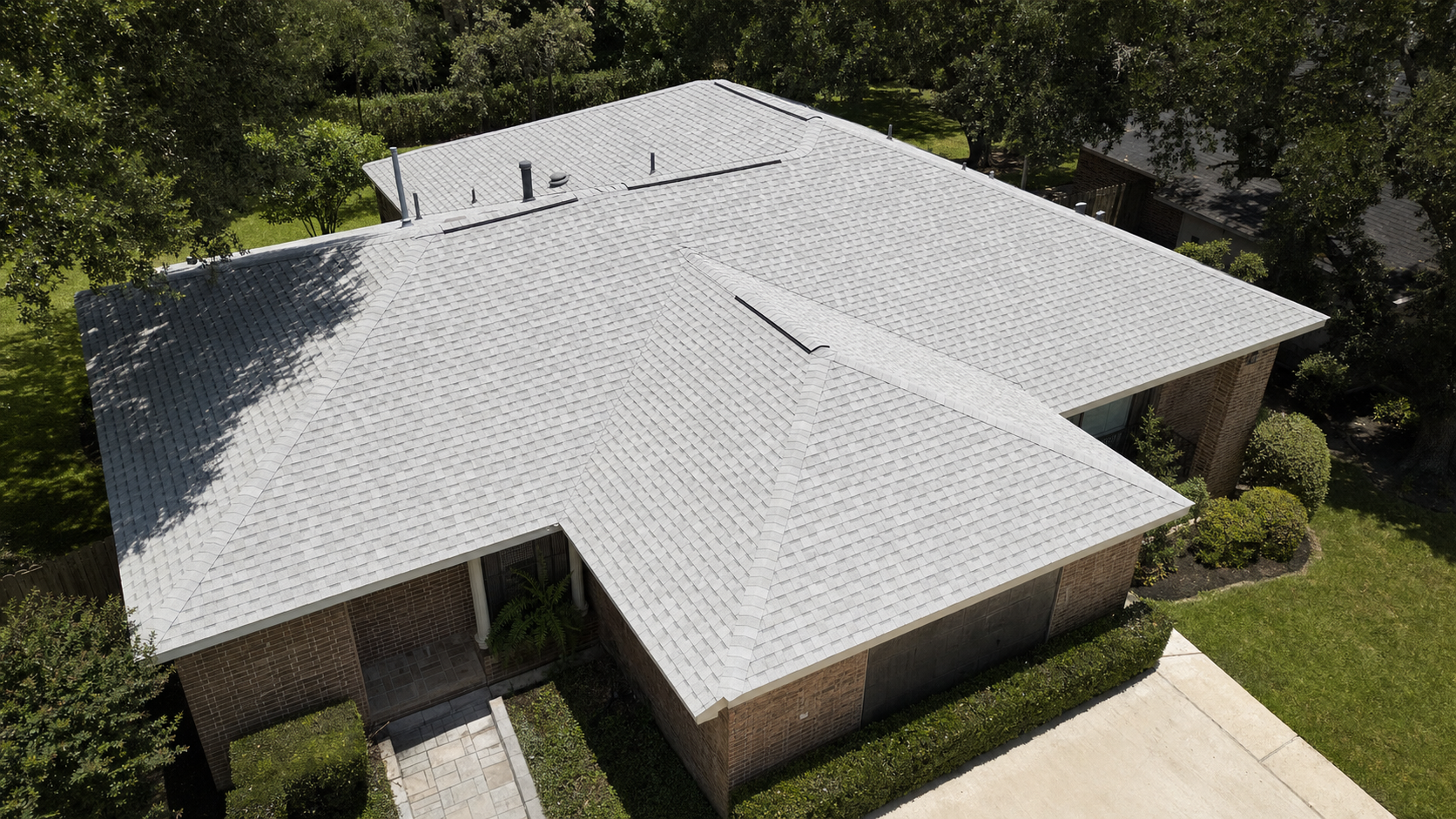 Aerial view of a Houston hip roof covered in light-colored cool-roof asphalt shingles designed for high solar reflectance