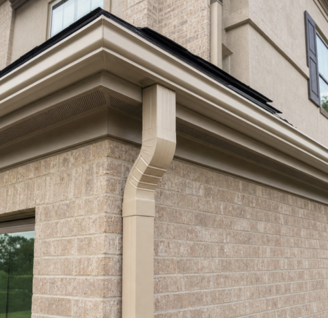 Houston home corner showing K-style aluminum gutter and 3x4 downspout against brick