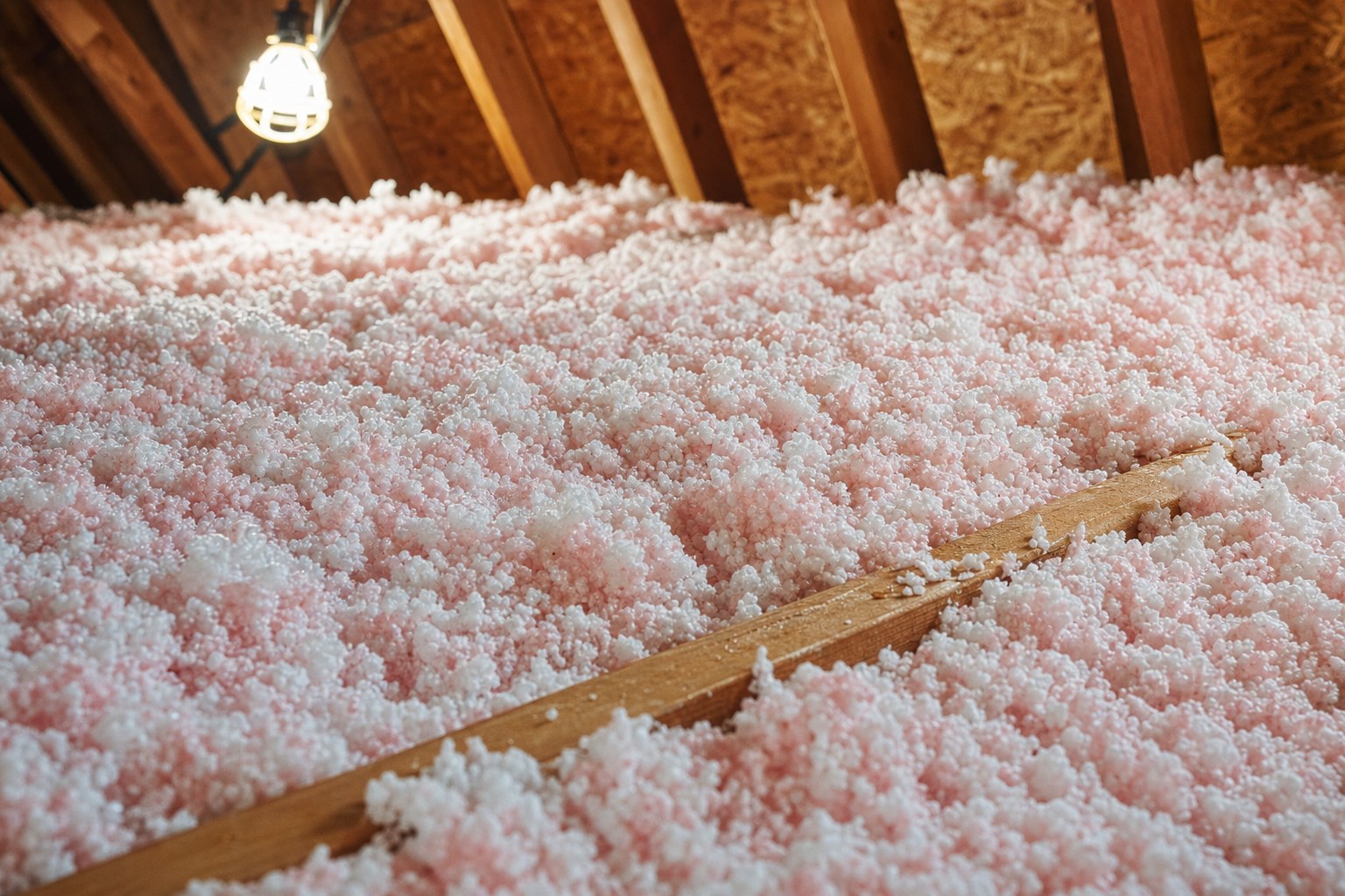 Blown loose-fill attic insulation over joists in a Houston attic
