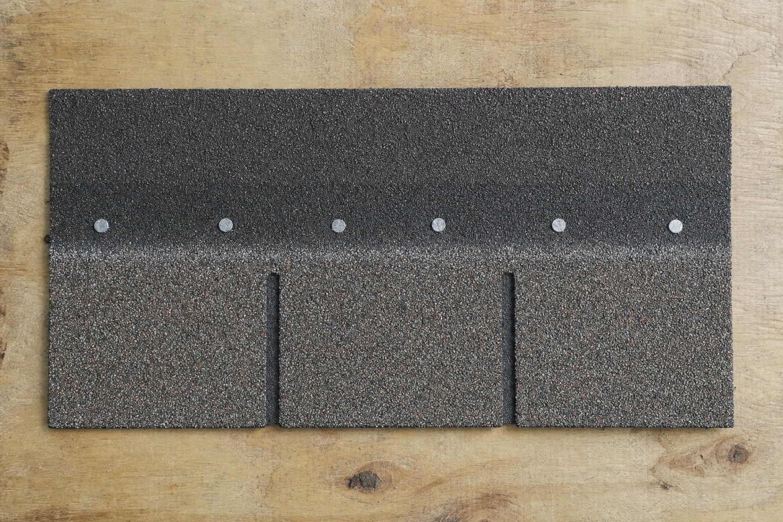 Six-nail pattern on an asphalt shingle sample on plywood