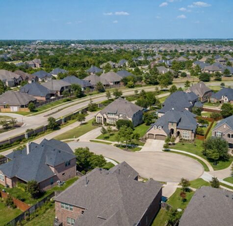 Aerial view of a Katy Texas HOA master-planned neighborhood with uniform shingle rooflines