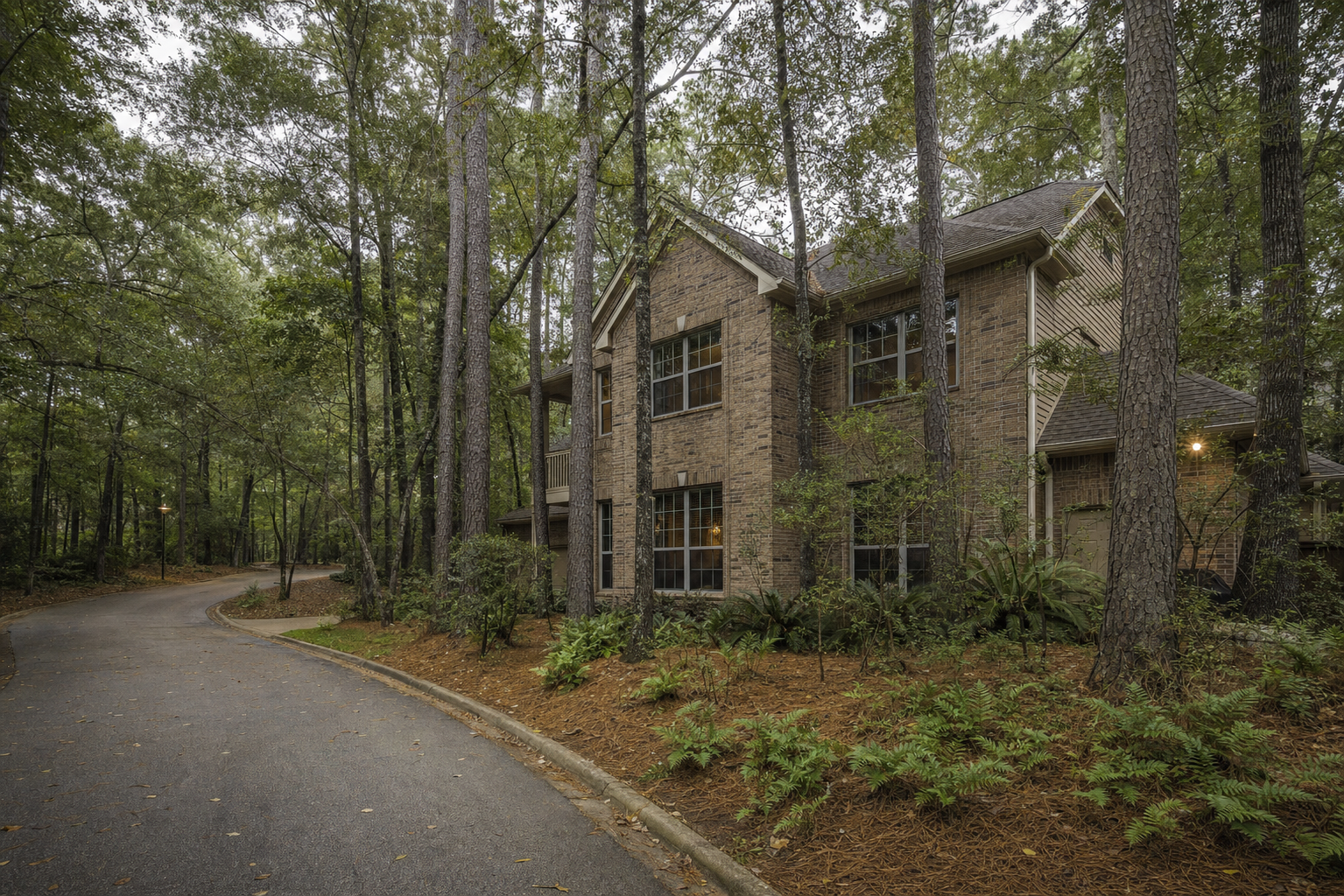 Two-story brick Kingwood Houston home nestled among mature loblolly pines with a pine-straw yard and quiet forest street