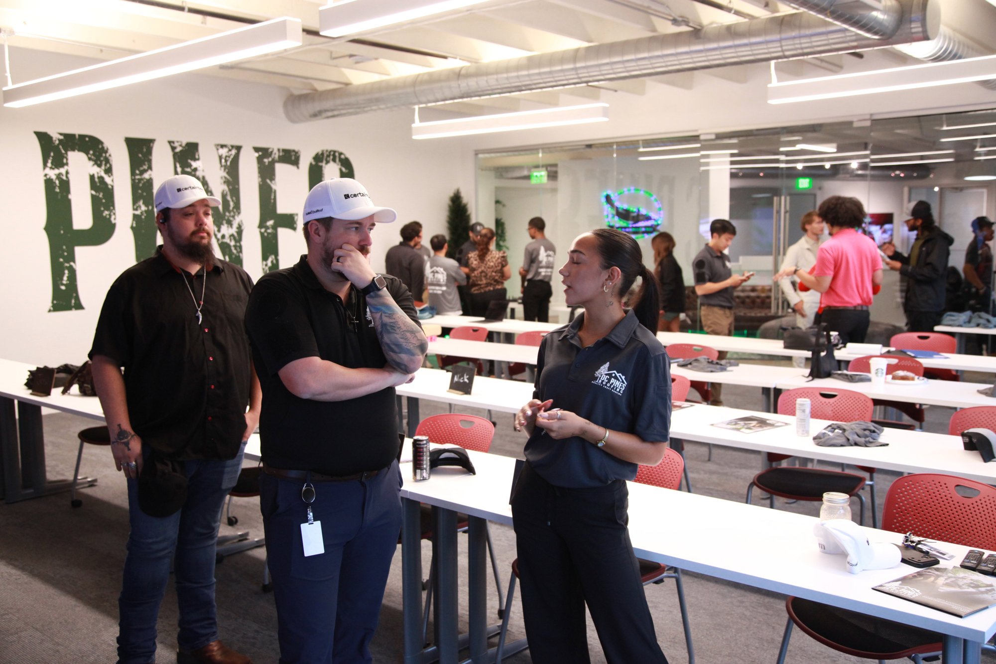 DC Pines Roofing team members talking in the Houston office training space