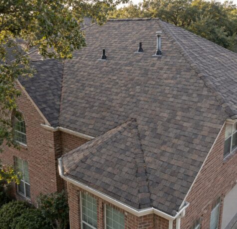 Shingle roof on a brick Houston home with plumbing vent pipes and roof pipe boots